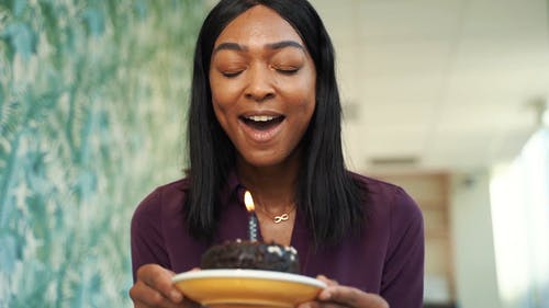 一个女人吹生日蛋糕蜡烛 · 免费素材视频
