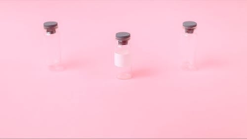 粉红色表面上的三个小瓶 · 免费素材视频