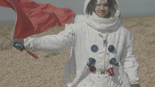 男人穿着太空服，挥舞着国旗 · 免费素材视频