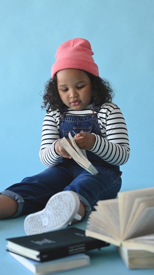 坐在地板上的年轻女孩看书 · 免费素材视频