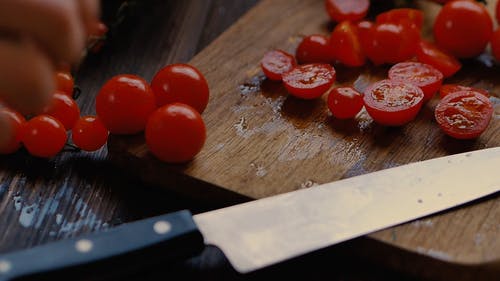 一个人用刀切樱桃西红柿的特写视图 · 免费素材视频