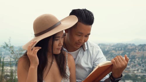 一对亚洲夫妇读一本书 · 免费素材视频