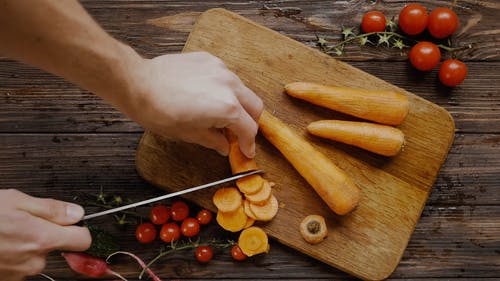 一个人用刀切成薄片的胡萝卜 · 免费素材视频