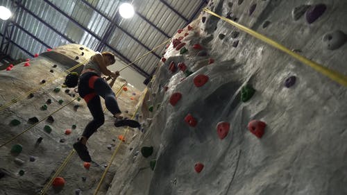 低角度拍摄的女人从攀岩墙走下 · 免费素材视频