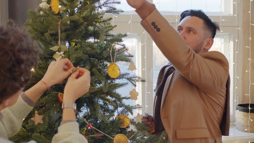 一对夫妇装饰圣诞树 · 免费素材视频